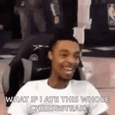 Man Sitting In Chair Smiling Eating Whole Cheesesteak GIF