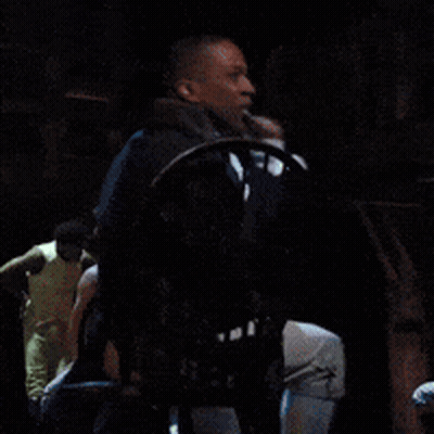 Man Sitting In Chair With Hand Up GIF