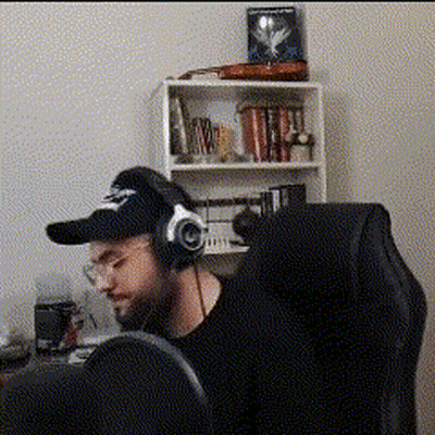 Man Sitting In Chair With Headphones And Baseball Cap GIF