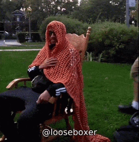 Man Sitting In Chair With Orange Blanket On Head And @Looseboxer GIF
