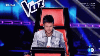 Man Sitting in Chair with Voz Sign