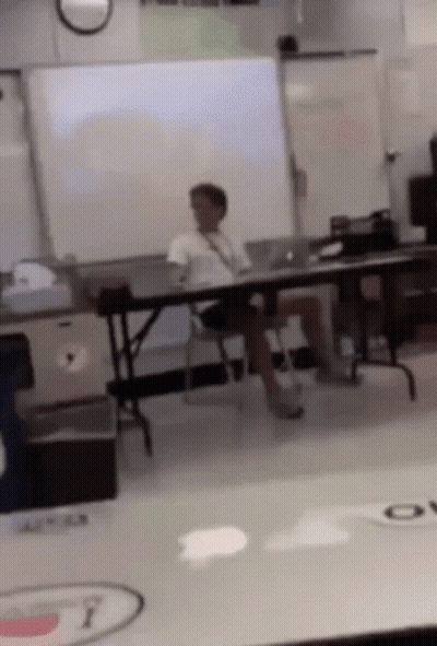 Man Sitting In Classroom With Legs Crossed GIF