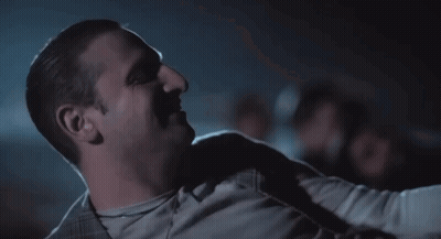 Man Sitting In Dark Room With Arm Around Shoulder GIF