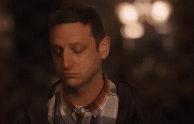 Man Sitting in Dark Room With Arm Around Shoulder