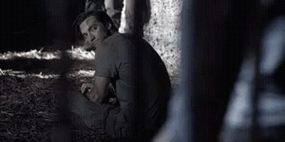 Man Sitting In Dark Room With Fence GIF
