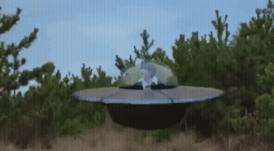 Man Sitting In Flying Saucer In Field GIF