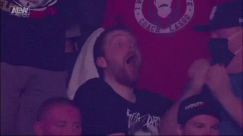 Man Sitting In Front Of AEW Sign GIF