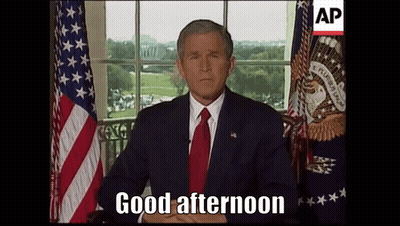 Man Sitting In Front Of American Flag Saying Good Afternoon GIF