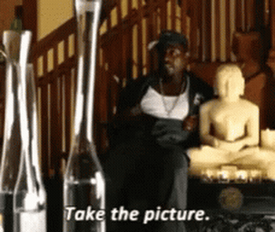 Man Sitting In Front Of Buddha Statue Take The Picture GIF
