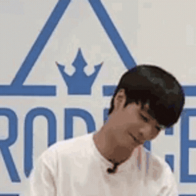 Man Sitting In Front Of Crowned Sign Looking Down GIF