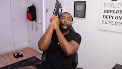 Man Sitting In Front Of Deploy Sign GIF
