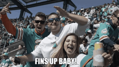 Man Sitting In Front Of Dolphin Wall Saying Fins Up GIF