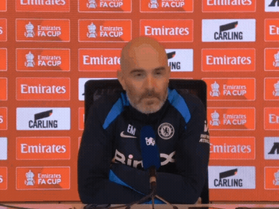 Man Sitting In Front Of Emirates FA Cup Banner GIF