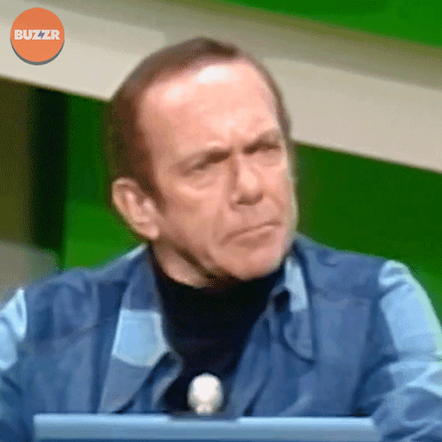 Man Sitting In Front Of Green Screen With Buzzr Logo GIF