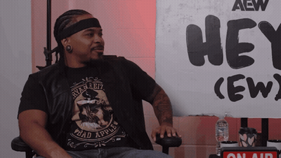 Man Sitting In Front Of Hey Crew Sign GIF