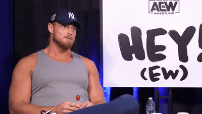 Man Sitting in Front of Hey (Ew) Sign