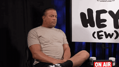 Man Sitting In Front Of Hey (Ew) Sign GIF