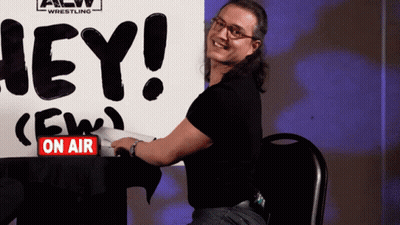 Man Sitting In Front Of Hey Sign GIF