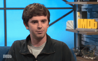 Man Sitting In Front Of IMDb Sign GIF