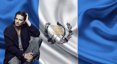 Man Sitting In Front Of Libertad Flag GIF