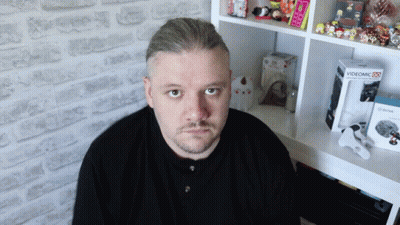 Man Sitting In Front Of Shelf With Videomic Box GIF