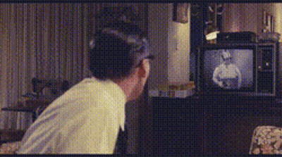 Man Sitting In Front Of TV With Man Picture GIF