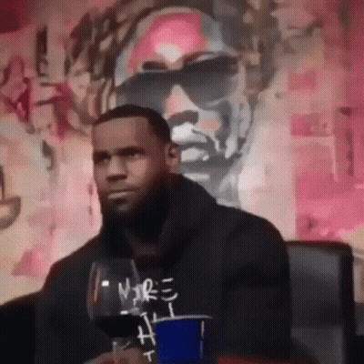 Man Sitting In Front Of Wall With Painting Of Sunglasses GIF