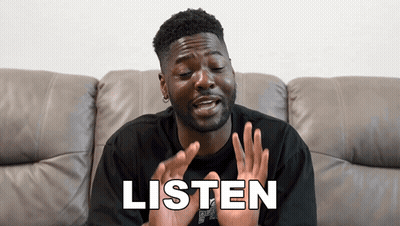 Man Sitting In Grass Covering Ears GIF