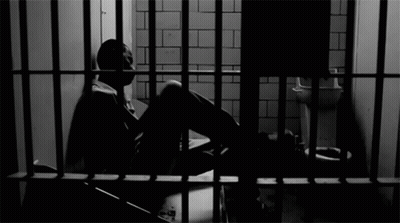 Man Sitting In Jail Cell GIF