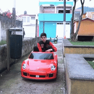 Man Sitting In Red Toy Car With D GIF