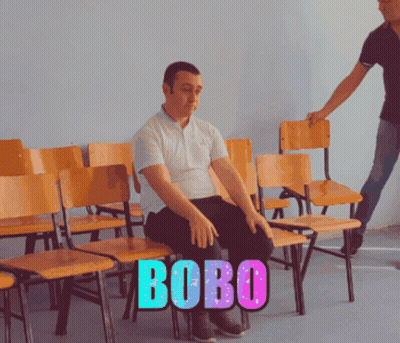 Man Sitting In Row Of Chairs With Bobo GIF