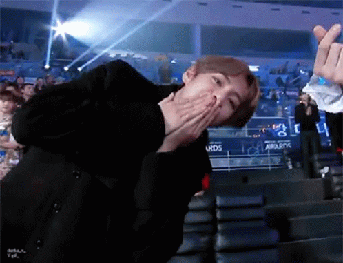 Man Sitting In Stadium With Hand On Mouth GIF