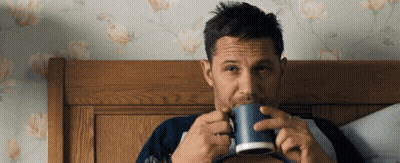 Man Sitting On Bed Drinking Blue Mug GIF