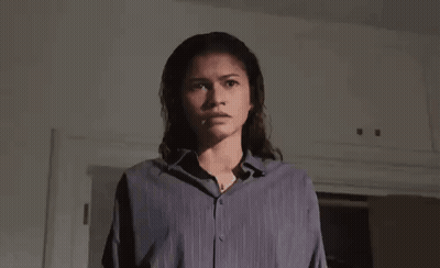 Man Sitting On Bed Holding Paper And Knife GIF