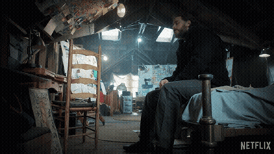 Man Sitting On Bed In Attic With Netflix Logo GIF
