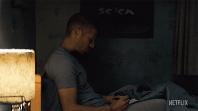 Man Sitting On Bed In Front Of Setek Poster GIF