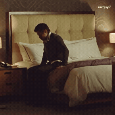 Man Sitting On Bed With Harryxgif Watermark GIF