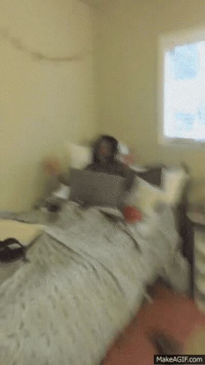 Man Sitting On Bed With Laptop Screaming GIF