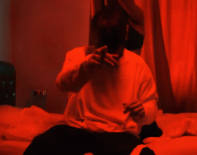 Man Sitting On Bed With Woman In Red Light GIF