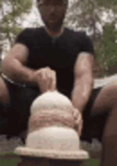Man Sitting On Bench Holding Cake GIF
