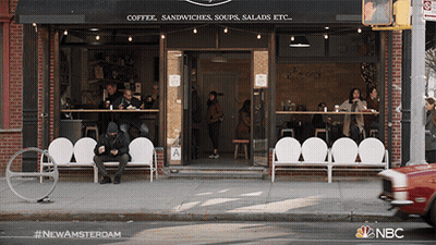 Man Sitting On Bench In Front Of Coffee Shop GIF