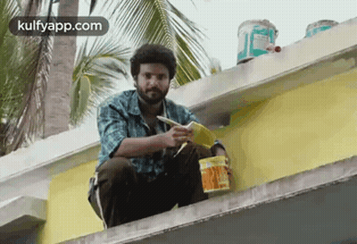 Man Sitting On Building Edge Holding Paint Bucket And Brush GIF