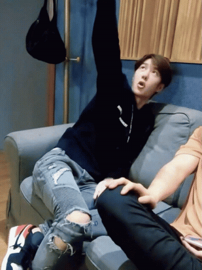 Man Sitting On Couch Arms Up Supreme Sweater GIF