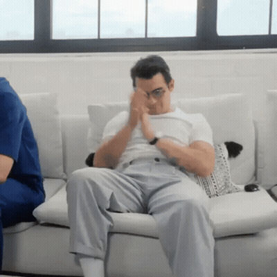 Man Sitting On Couch Covering Eyes GIF