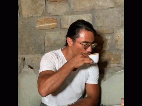 Man Sitting On Couch Drinking From Cup GIF