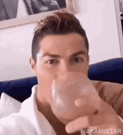 Man Sitting On Couch Drinking Water GIF