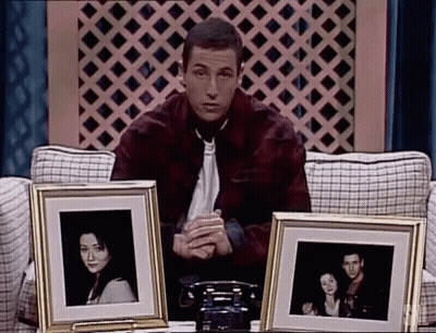 Man Sitting On Couch Holding Framed Photos GIF