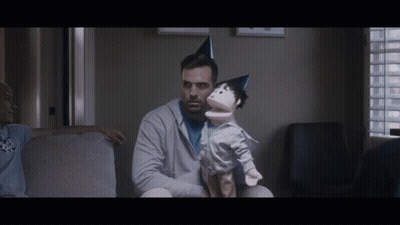 Man Sitting on Couch Holding Puppet