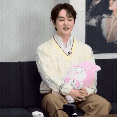 Man Sitting On Couch Holding Stuffed Animal GIF