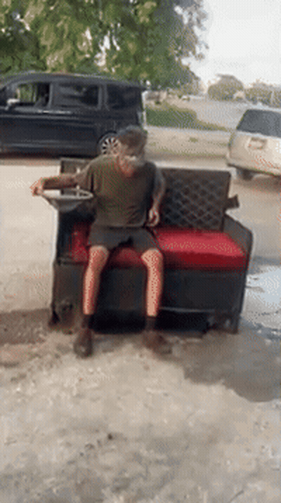 Man Sitting On Couch In Driveway With Van GIF